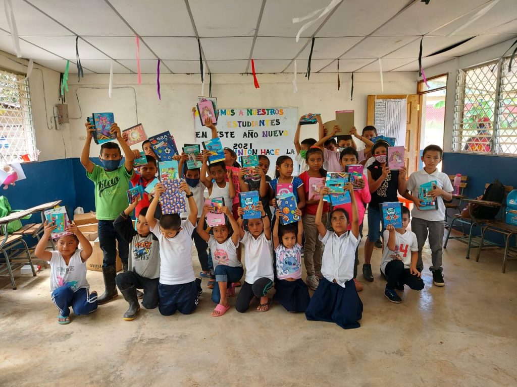 Niños de la Escuela San Francisco de Asís de la comunidad San Miguel #1 posan sonrientes con sus útiles escolares.