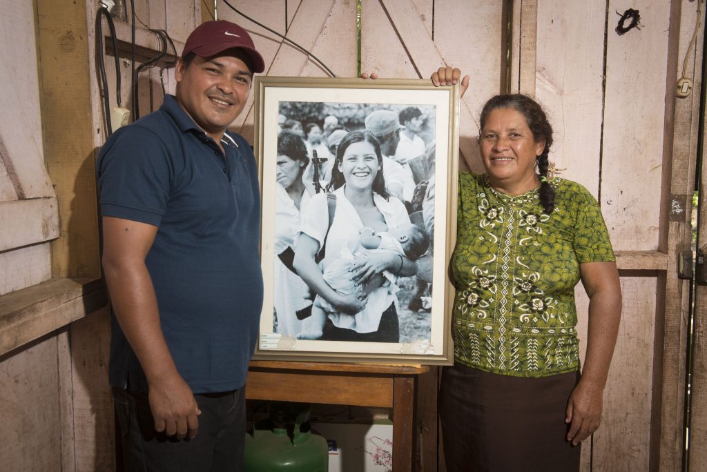 Blanca López Hernández poses with her son José Antonio López Pérez and the photograph of "the militia from Waswalito" in which they both appear.