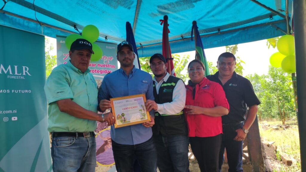 Gino Zambrano, Jefe de Operaciones de MLR Forestal, sostiene el certificado que acredita a la Finca Matiz como Reserva Silvestre Privada.